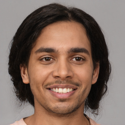 Joyful latino young-adult male with medium  brown hair and brown eyes