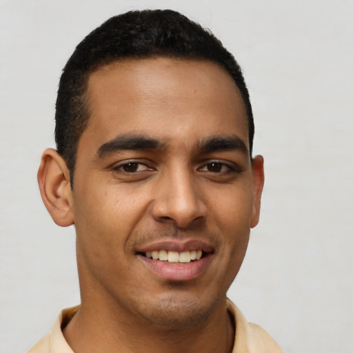 Joyful latino young-adult male with short  brown hair and brown eyes