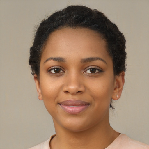 Joyful black young-adult female with short  black hair and brown eyes