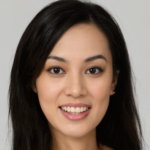 Joyful latino young-adult female with long  brown hair and brown eyes