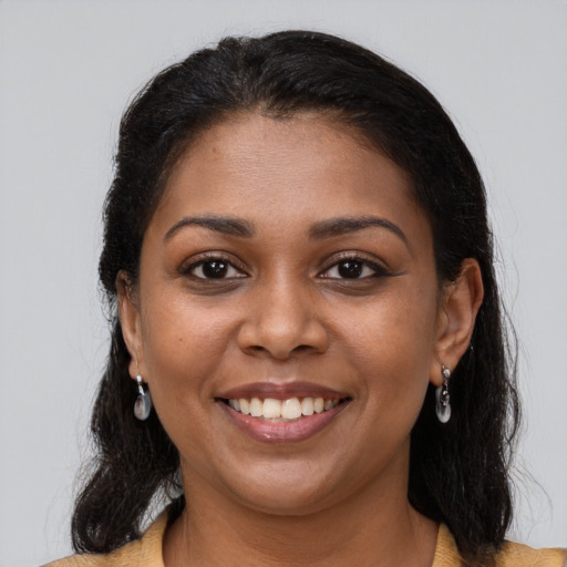 Joyful black young-adult female with long  brown hair and brown eyes