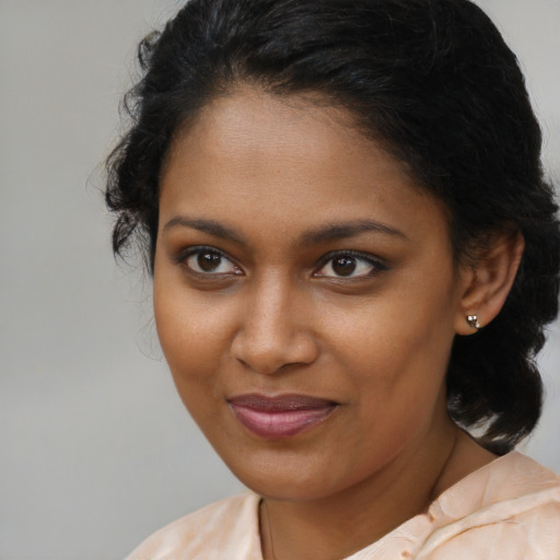 Joyful black young-adult female with medium  brown hair and brown eyes