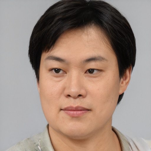 Joyful asian adult male with short  brown hair and brown eyes
