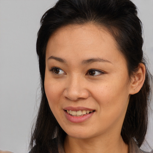 Joyful black young-adult female with long  brown hair and brown eyes