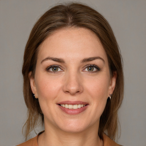 Joyful white young-adult female with medium  brown hair and grey eyes