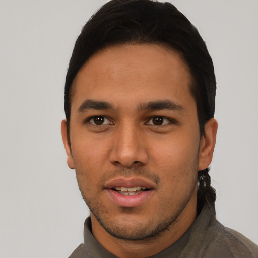 Joyful latino young-adult male with short  black hair and brown eyes