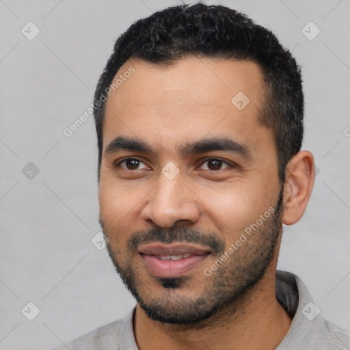 Joyful latino young-adult male with short  black hair and brown eyes