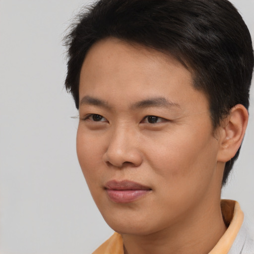 Joyful asian young-adult male with short  black hair and brown eyes