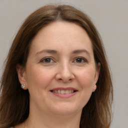 Joyful white adult female with long  brown hair and grey eyes