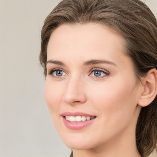 Joyful white young-adult female with medium  brown hair and green eyes