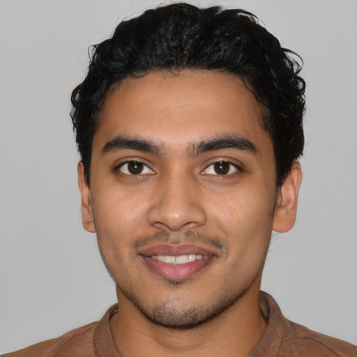 Joyful latino young-adult male with short  black hair and brown eyes