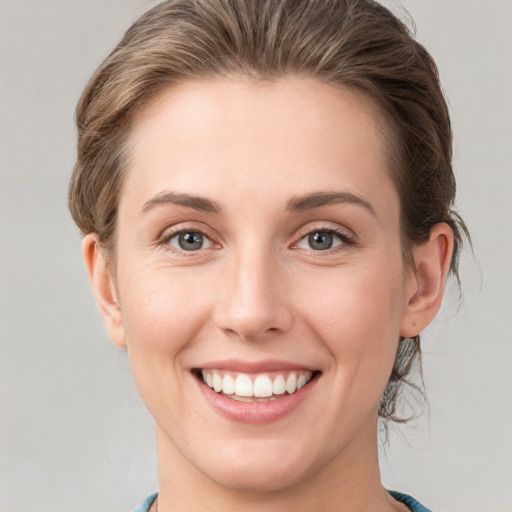 Joyful white young-adult female with medium  brown hair and grey eyes