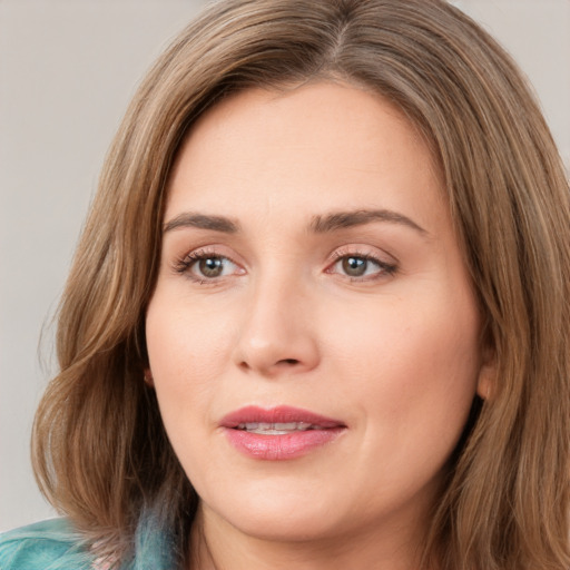 Joyful white young-adult female with long  brown hair and green eyes