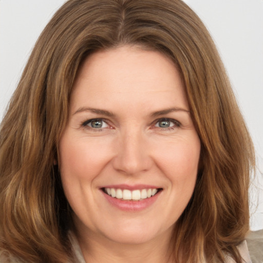 Joyful white young-adult female with long  brown hair and green eyes