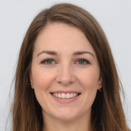 Joyful white young-adult female with long  brown hair and grey eyes