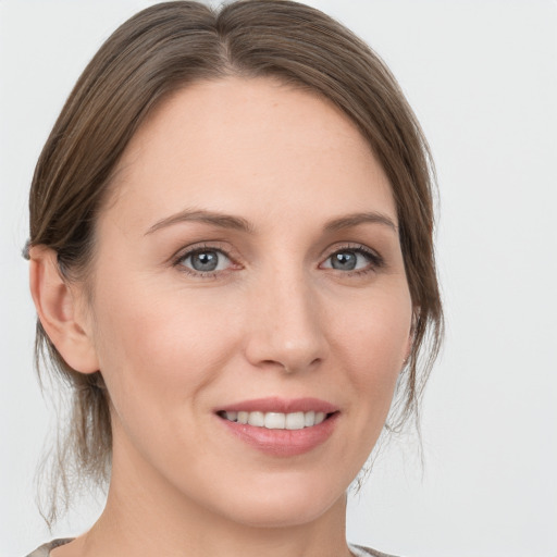 Joyful white young-adult female with medium  brown hair and grey eyes