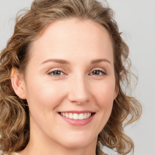 Joyful white young-adult female with medium  brown hair and blue eyes