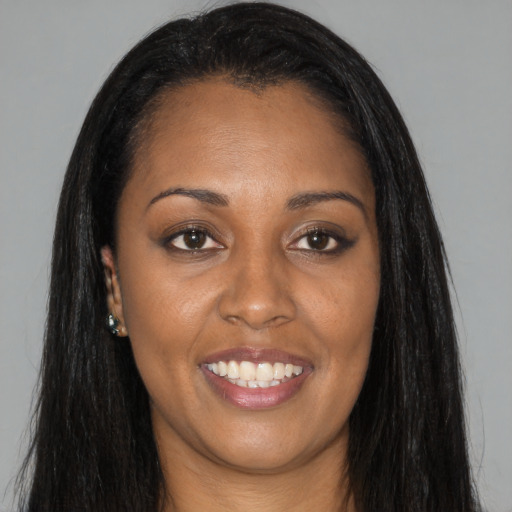 Joyful black young-adult female with long  black hair and brown eyes