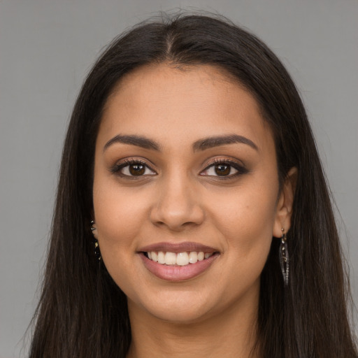 Joyful latino young-adult female with long  brown hair and brown eyes