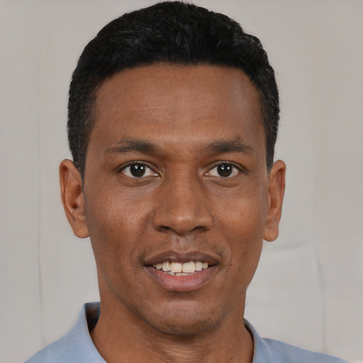 Joyful black young-adult male with short  black hair and brown eyes