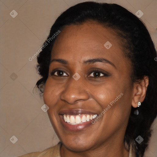 Joyful black adult female with long  brown hair and brown eyes