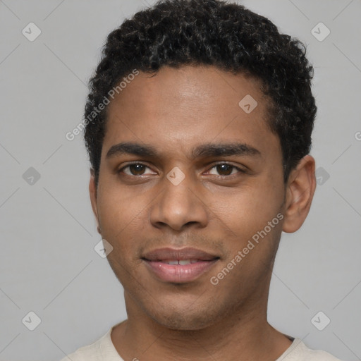 Joyful black young-adult male with short  brown hair and brown eyes