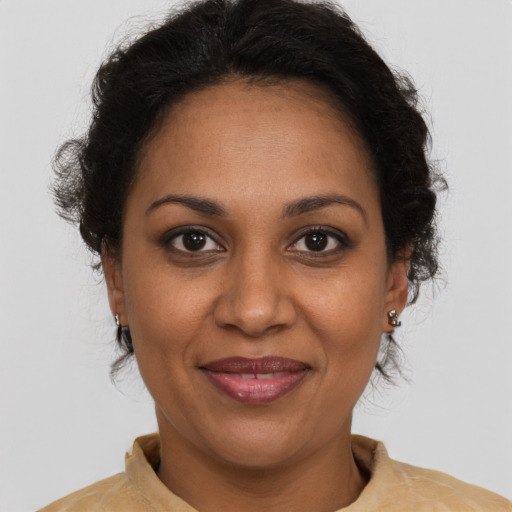 Joyful black adult female with medium  brown hair and brown eyes