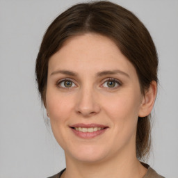 Joyful white young-adult female with medium  brown hair and grey eyes