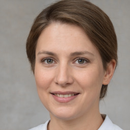 Joyful white adult female with medium  brown hair and grey eyes