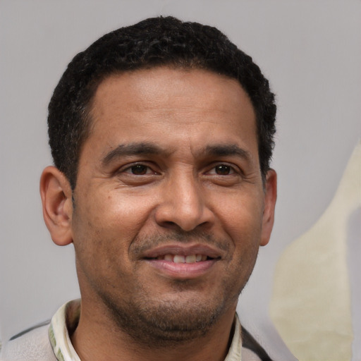 Joyful latino adult male with short  black hair and brown eyes