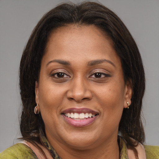 Joyful latino adult female with medium  brown hair and brown eyes