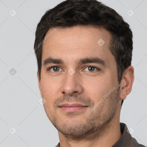 Joyful white young-adult male with short  black hair and brown eyes