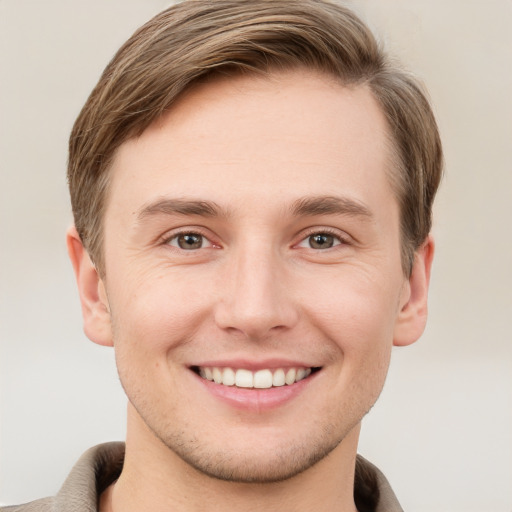 Joyful white young-adult male with short  brown hair and grey eyes