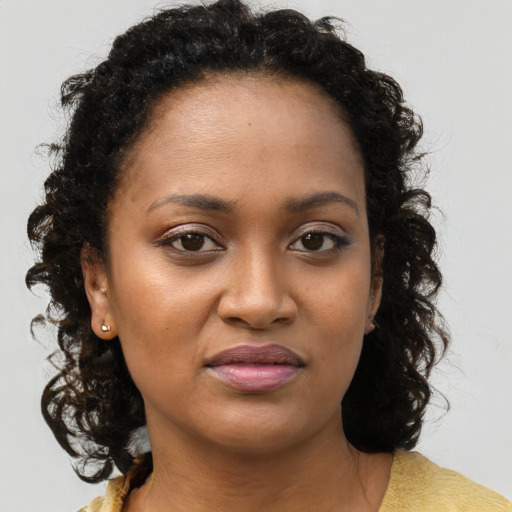 Joyful black young-adult female with medium  brown hair and brown eyes