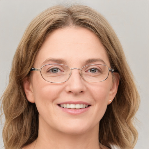 Joyful white adult female with medium  brown hair and blue eyes