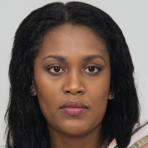 Joyful black young-adult female with long  brown hair and brown eyes