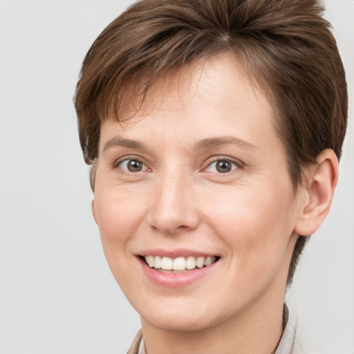 Joyful white young-adult female with short  brown hair and grey eyes