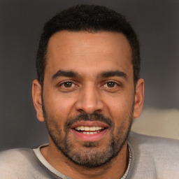 Joyful black young-adult male with short  brown hair and brown eyes