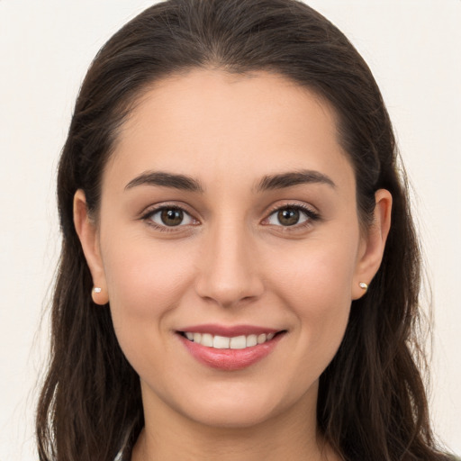 Joyful white young-adult female with long  brown hair and brown eyes