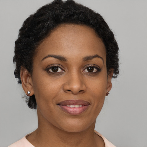 Joyful black young-adult female with short  brown hair and brown eyes