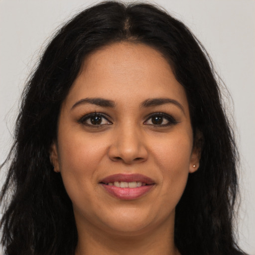 Joyful latino young-adult female with long  brown hair and brown eyes