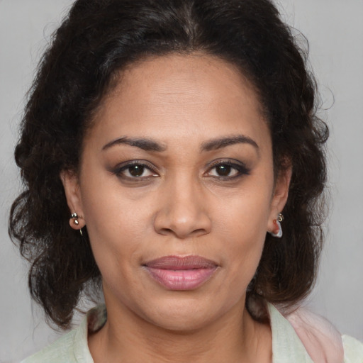 Joyful latino adult female with medium  brown hair and brown eyes