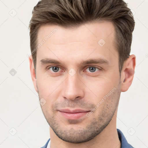 Joyful white young-adult male with short  brown hair and grey eyes