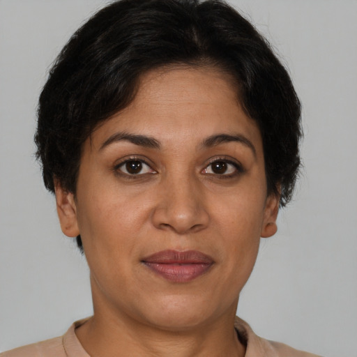 Joyful latino adult female with short  brown hair and brown eyes