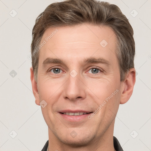 Joyful white adult male with short  brown hair and grey eyes