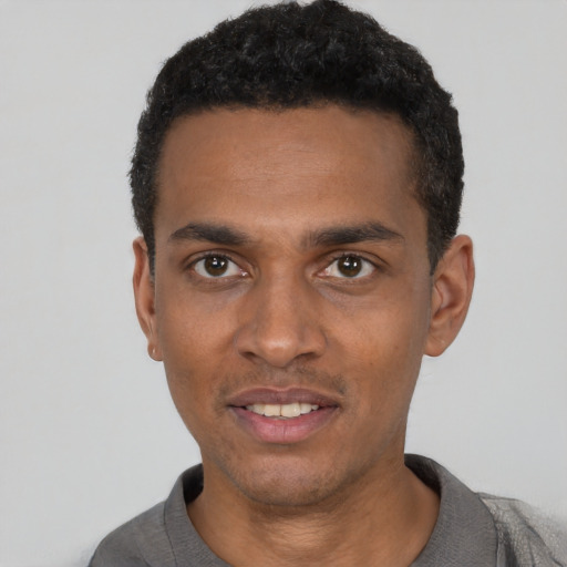 Joyful black young-adult male with short  black hair and brown eyes