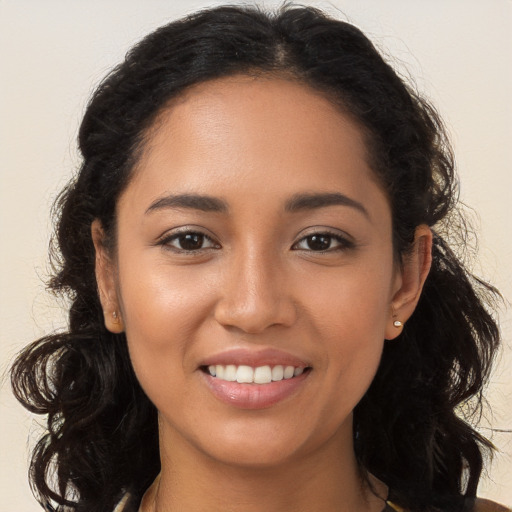 Joyful latino young-adult female with long  brown hair and brown eyes