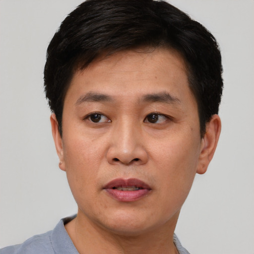 Joyful asian young-adult male with short  black hair and brown eyes