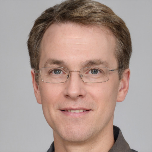 Joyful white adult male with short  brown hair and grey eyes