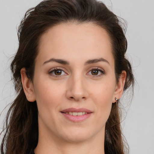 Joyful white young-adult female with long  brown hair and brown eyes